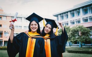 Two students celebrating at a graduation ceremony